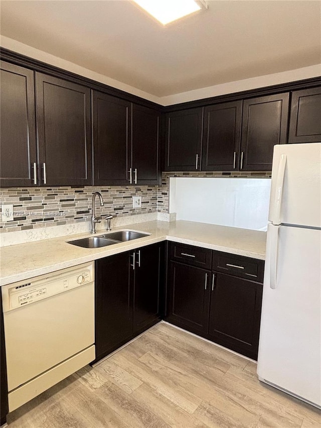 kitchen featuring sink, white appliances, decorative backsplash, and light hardwood / wood-style flooring