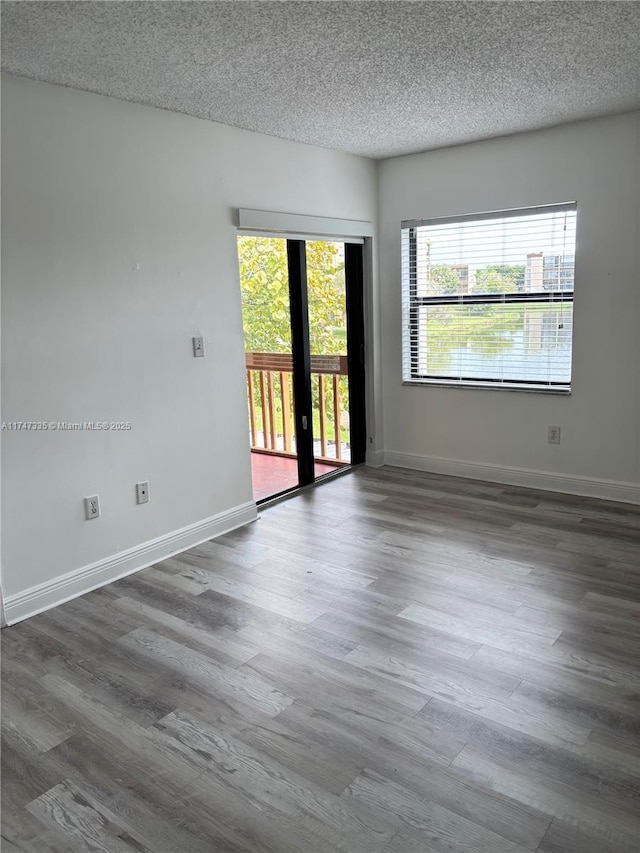 unfurnished room with dark wood-type flooring, french doors, and a textured ceiling