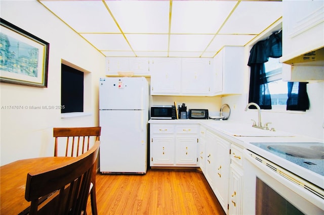 kitchen featuring white appliances, a sink, white cabinets, light countertops, and light wood finished floors