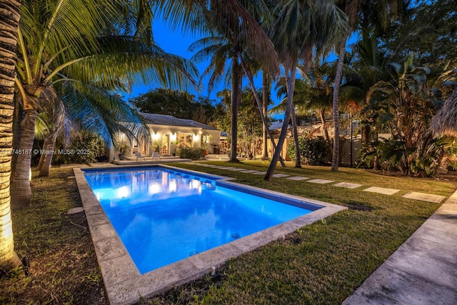 view of pool featuring an outbuilding and a lawn