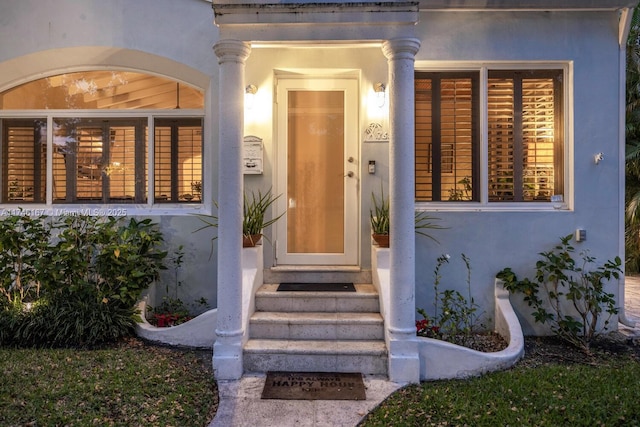 doorway to property featuring stucco siding