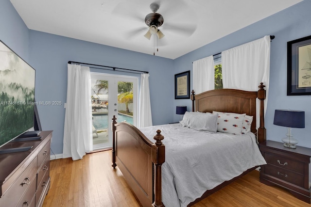 bedroom with ceiling fan, access to outside, multiple windows, and light wood-style flooring