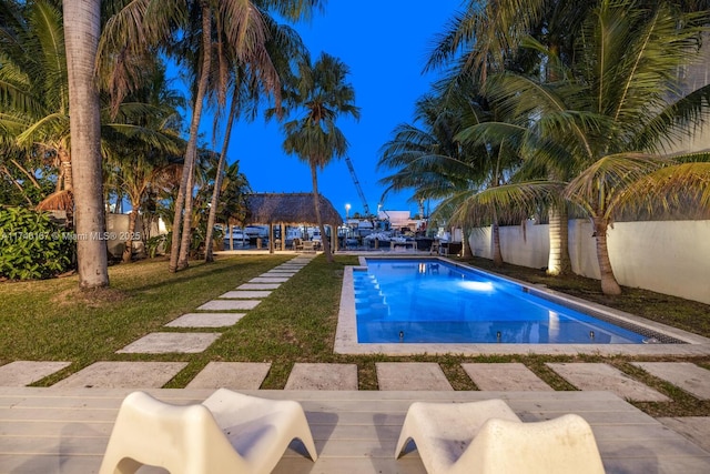 view of swimming pool featuring a fenced backyard, a fenced in pool, a lawn, and a gazebo