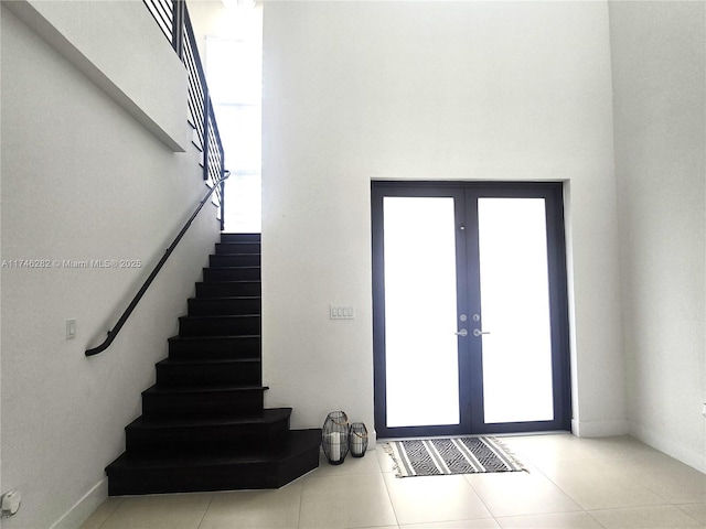 foyer with french doors, a wealth of natural light, and light tile patterned floors