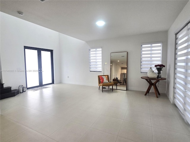 sitting room featuring french doors and light tile patterned floors