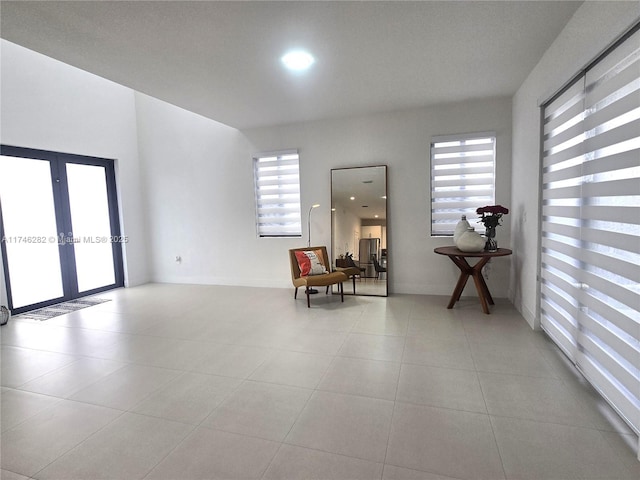 sitting room with french doors and light tile patterned floors