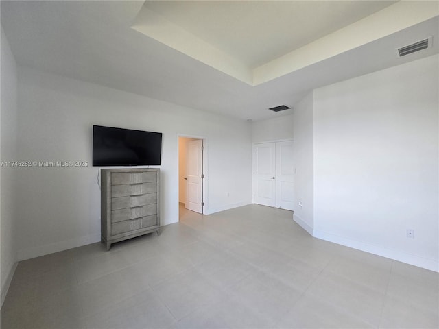 unfurnished bedroom featuring a raised ceiling
