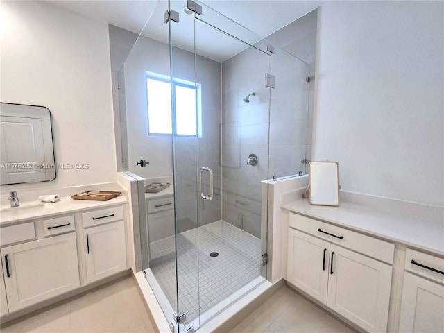 bathroom featuring a shower with shower door, vanity, and tile patterned floors