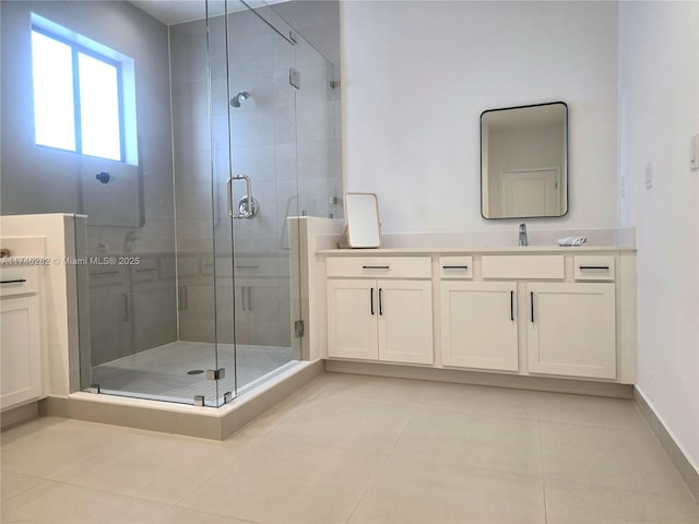 bathroom with tile patterned flooring, vanity, and walk in shower