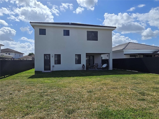 rear view of property featuring a lawn