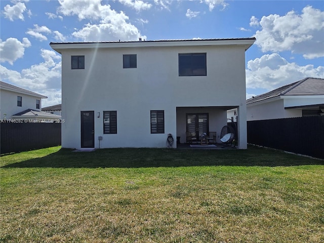 rear view of property with a yard and a patio