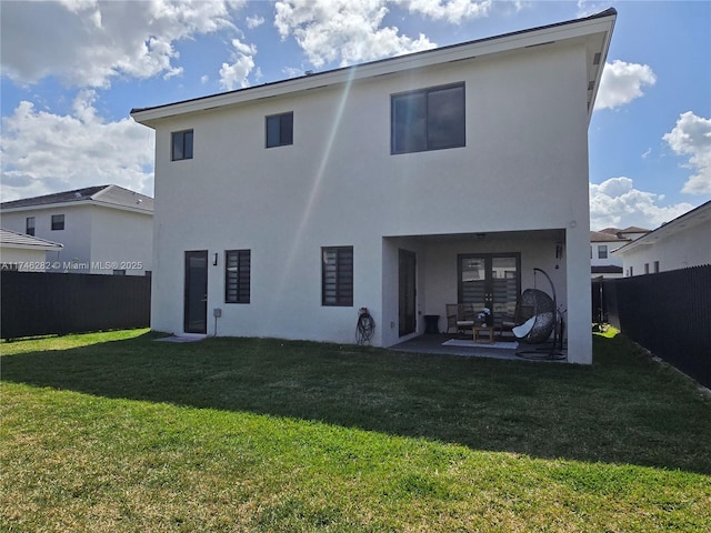 rear view of house featuring a patio area and a lawn