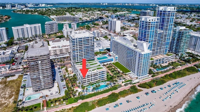 birds eye view of property with a water view and a beach view