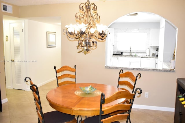 dining space with an inviting chandelier, baseboards, visible vents, and light tile patterned flooring