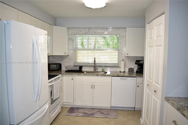 kitchen with white appliances, tasteful backsplash, white cabinetry, and a sink