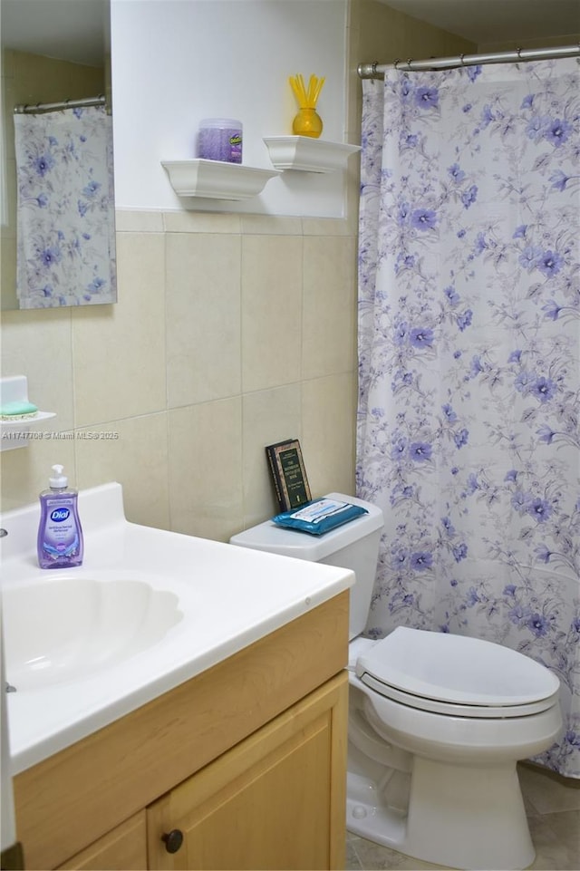 full bath with tile walls, vanity, toilet, and tile patterned floors