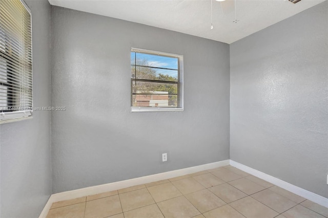 tiled empty room featuring ceiling fan