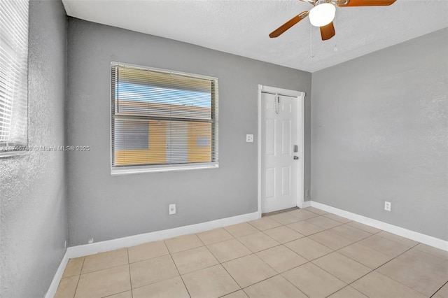 tiled spare room featuring ceiling fan and a textured ceiling