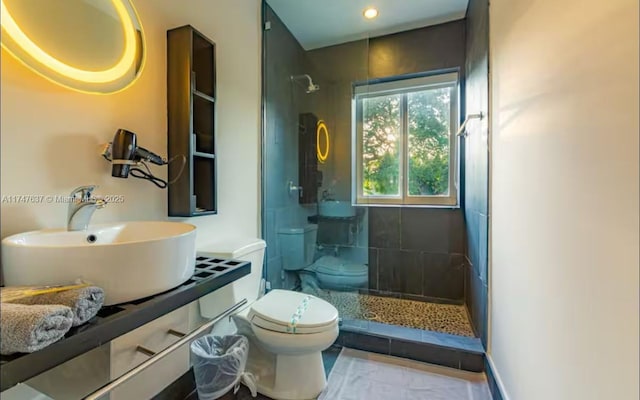 bathroom featuring sink, toilet, and a tile shower