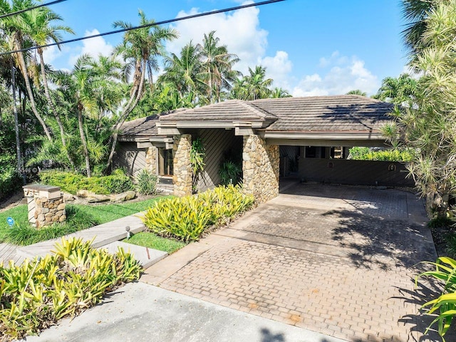 mid-century inspired home featuring a tiled roof and stone siding