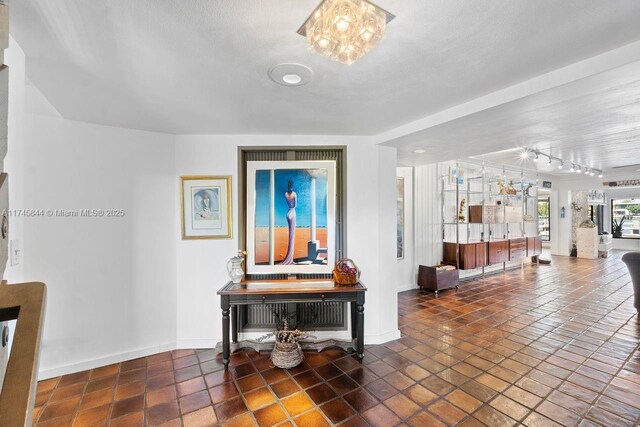 interior space with dark tile patterned floors, baseboards, and a textured ceiling