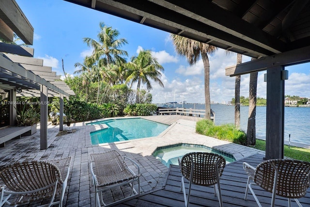 pool with an in ground hot tub, a patio, a water view, and a pergola