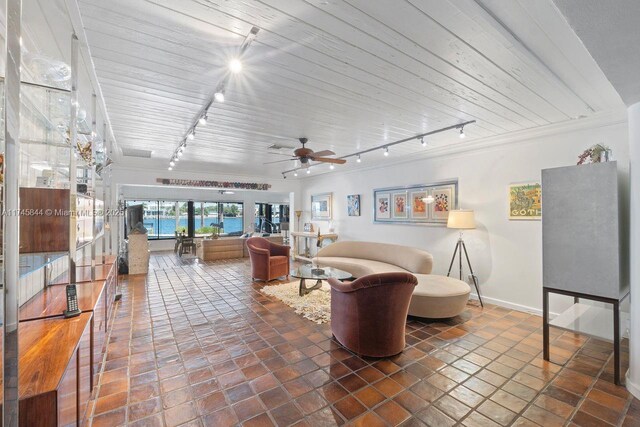 living area featuring rail lighting, baseboards, and a ceiling fan