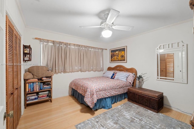 bedroom featuring light wood finished floors, a closet, a ceiling fan, and crown molding