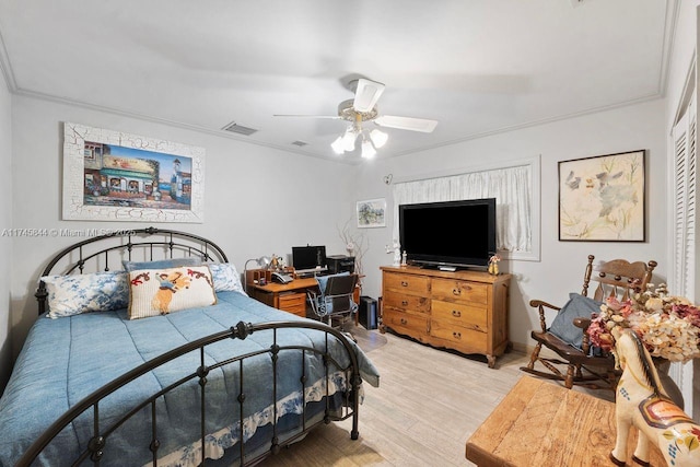 bedroom featuring ceiling fan, ornamental molding, visible vents, and light wood-style floors