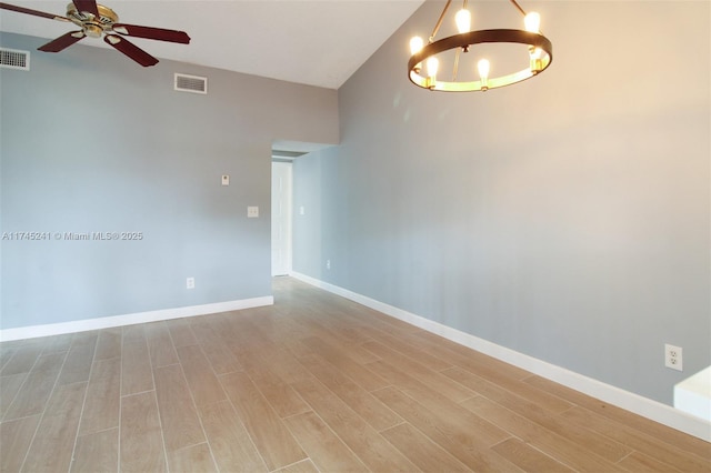 unfurnished room with light hardwood / wood-style floors and ceiling fan with notable chandelier