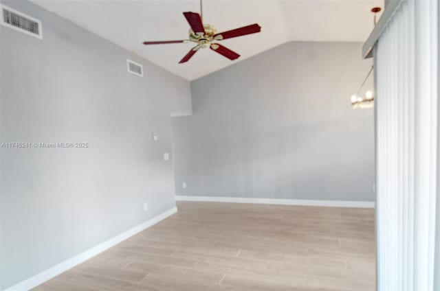 spare room with light hardwood / wood-style floors, vaulted ceiling, and ceiling fan