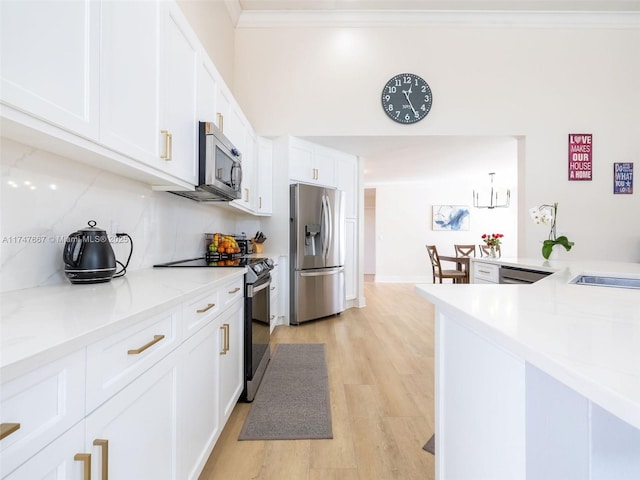 kitchen featuring stainless steel appliances, light hardwood / wood-style floors, white cabinets, crown molding, and decorative backsplash