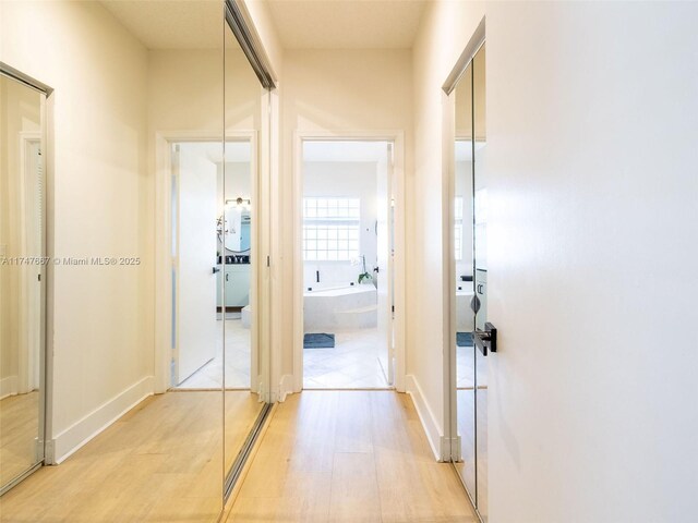 corridor with light wood-type flooring