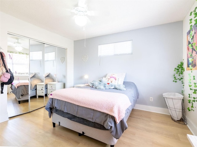 bedroom with ceiling fan, a closet, a textured ceiling, and light hardwood / wood-style floors