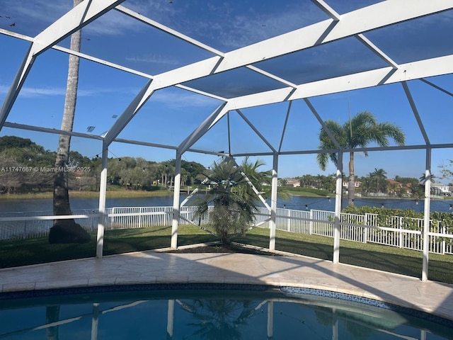 view of pool featuring a patio area, glass enclosure, and a water view