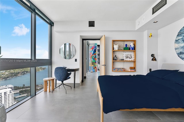 bedroom featuring expansive windows and a water view