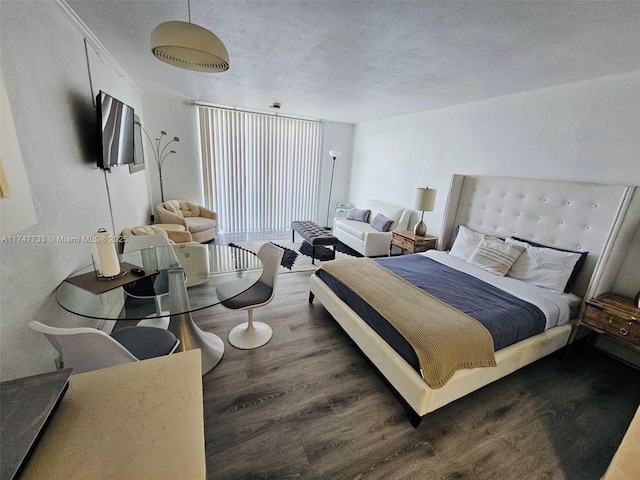 bedroom featuring dark hardwood / wood-style flooring and a textured ceiling