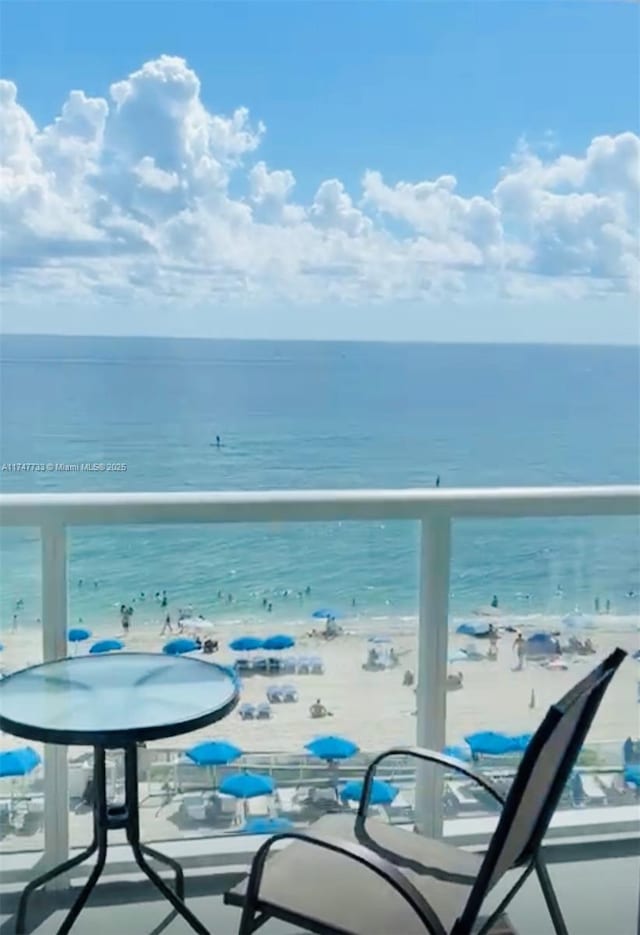 balcony with a water view and a beach view