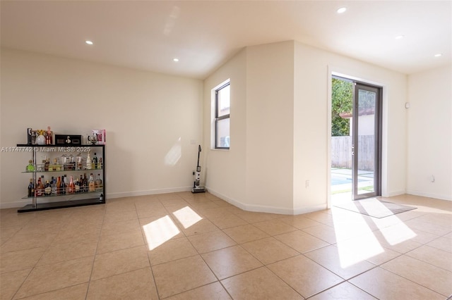 empty room featuring recessed lighting, baseboards, and light tile patterned floors