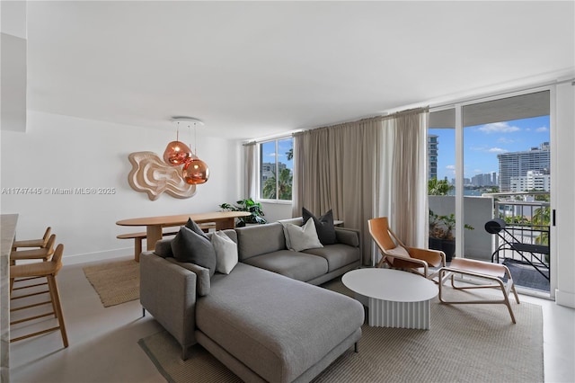 living room with floor to ceiling windows, a view of city, and baseboards