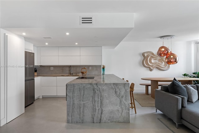 living area with visible vents, recessed lighting, and concrete flooring