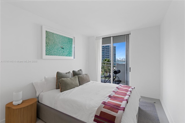 bedroom with access to exterior, baseboards, and expansive windows