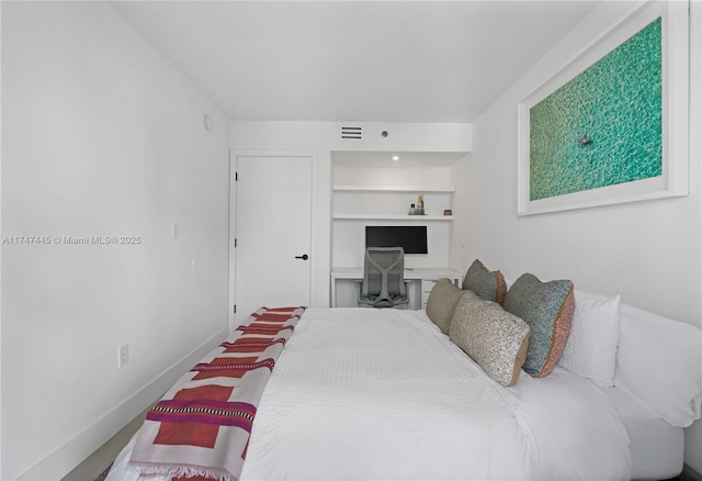 bedroom featuring visible vents, baseboards, and built in study area