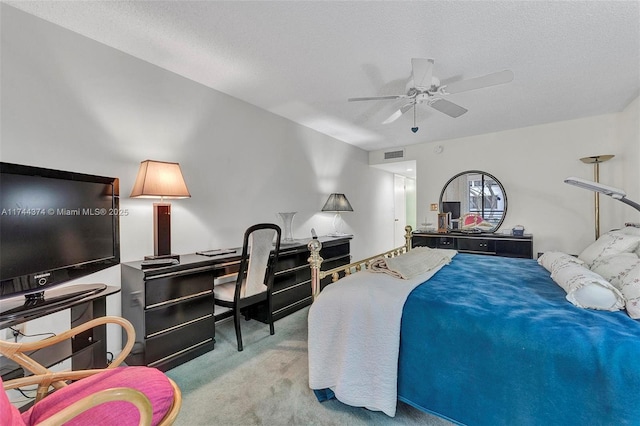 carpeted bedroom with ceiling fan and a textured ceiling