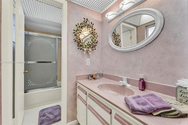 bathroom with combined bath / shower with glass door, vanity, and tile patterned floors