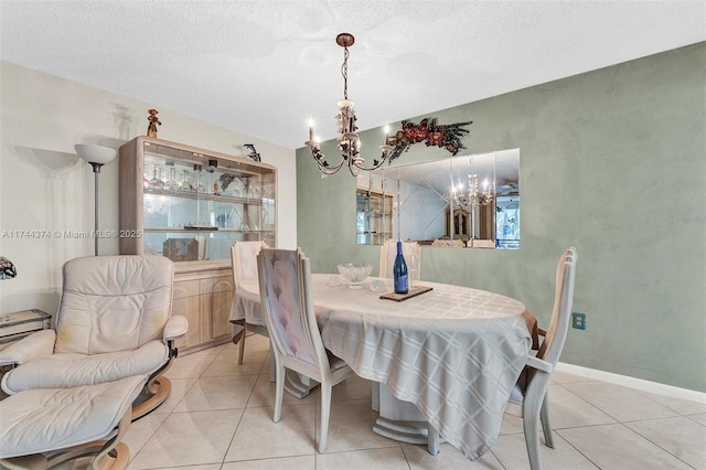 dining room featuring a textured ceiling, light tile patterned flooring, and an inviting chandelier