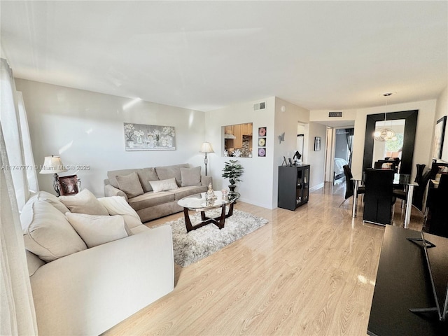 living room featuring light wood-type flooring and a chandelier