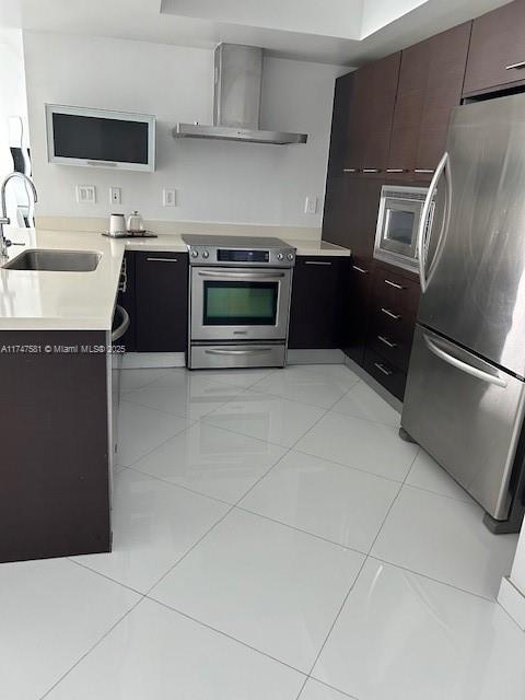 150 Sunny Isles Blvd Unit 1-606, Sunny Isles Beach, FL 33160 - kitchen featuring stainless steel appliances, wall chimney exhaust hood, light countertops, modern cabinets, and light tile patterned floors