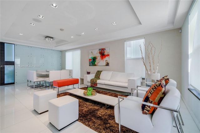 living room with a tray ceiling and light tile patterned floors