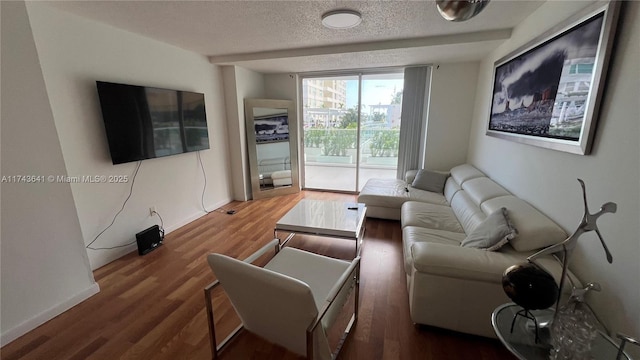 living room with a textured ceiling, wood finished floors, and baseboards
